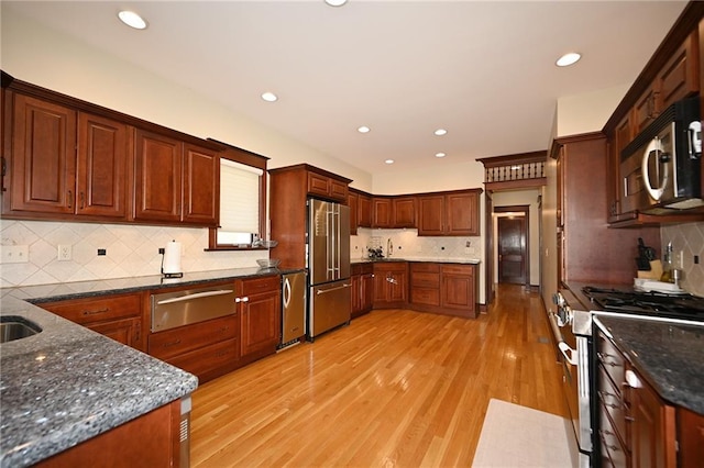 kitchen with a warming drawer, appliances with stainless steel finishes, light wood-style flooring, and recessed lighting