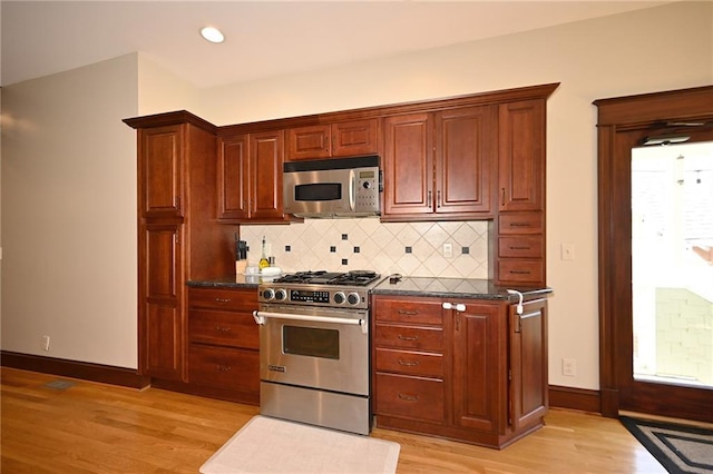 kitchen featuring light wood-style floors, baseboards, backsplash, and stainless steel appliances