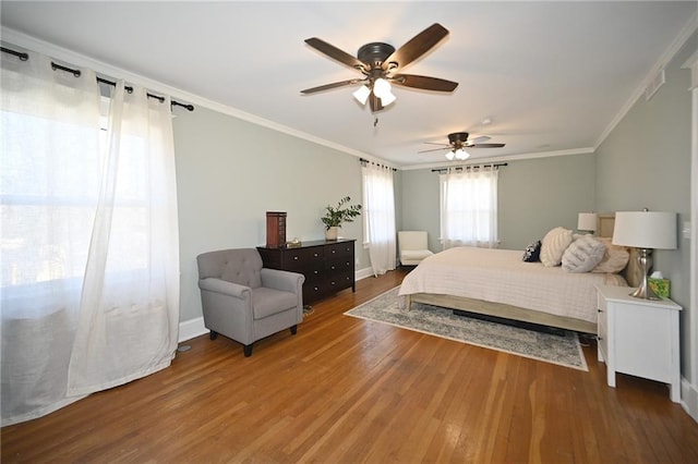 bedroom with a ceiling fan, wood finished floors, baseboards, and ornamental molding