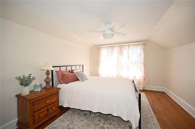 bedroom with a ceiling fan, lofted ceiling, wood finished floors, and baseboards