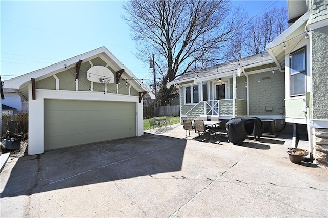 exterior space with fence, an outdoor structure, concrete driveway, a garage, and central air condition unit