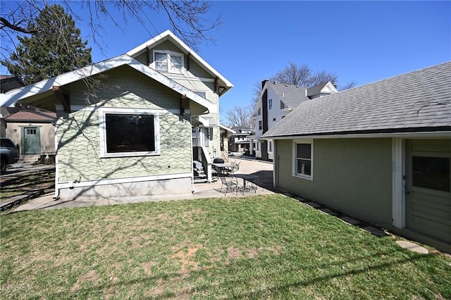 back of house with a patio area and a yard