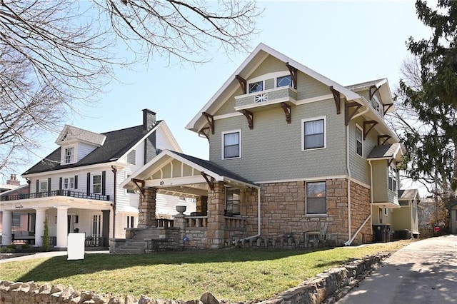 exterior space with stone siding, a lawn, and central AC