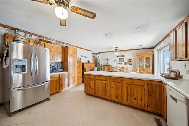 kitchen with white dishwasher, a peninsula, light countertops, stainless steel fridge with ice dispenser, and brown cabinetry