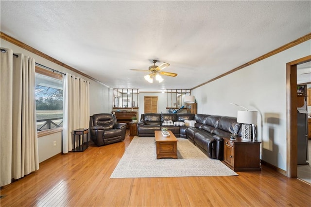 living area with crown molding, a textured ceiling, and wood finished floors