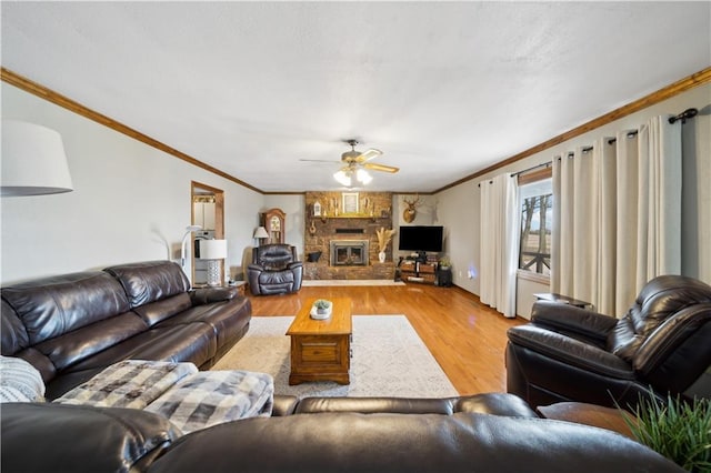 living area featuring ceiling fan, a fireplace, ornamental molding, and wood finished floors