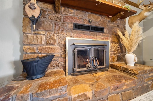 room details with a glass covered fireplace and visible vents