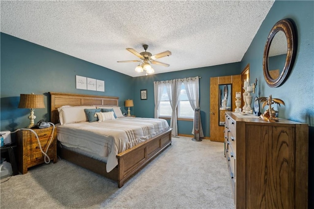 bedroom with light carpet, ceiling fan, and a textured ceiling