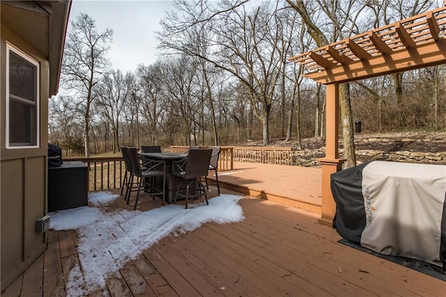 wooden deck with outdoor dining space, area for grilling, and a pergola