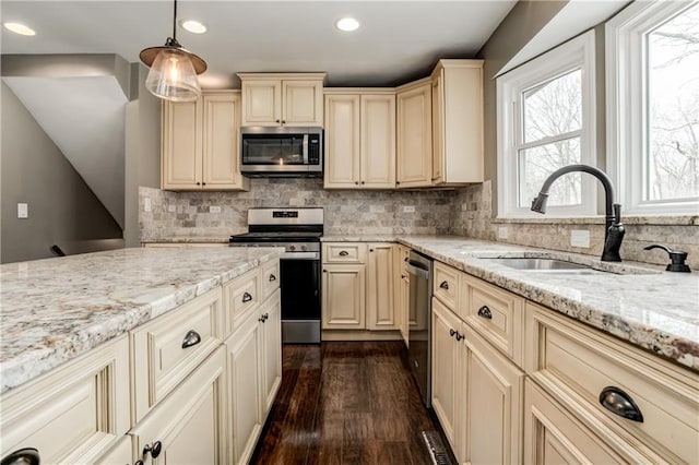 kitchen featuring cream cabinets, appliances with stainless steel finishes, and a sink