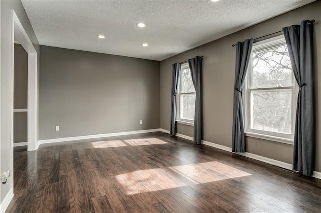 spare room featuring recessed lighting, baseboards, and wood finished floors