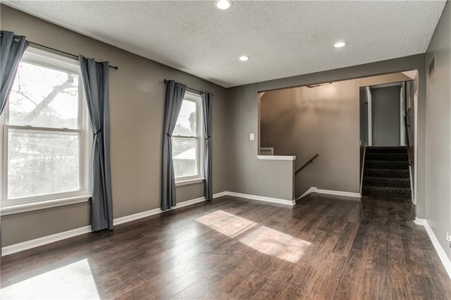 unfurnished room featuring recessed lighting, visible vents, a textured ceiling, wood finished floors, and baseboards