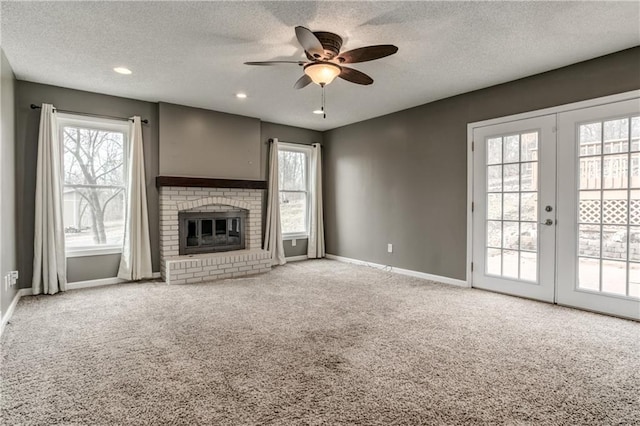 unfurnished living room featuring carpet, a fireplace, baseboards, and ceiling fan