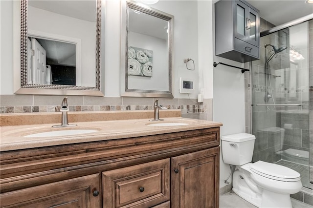 bathroom featuring toilet, a shower stall, and a sink