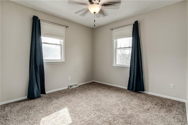 unfurnished room with a healthy amount of sunlight, ceiling fan, and a textured ceiling