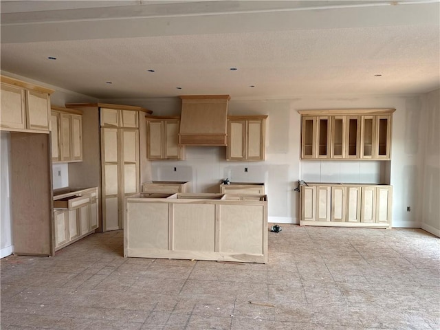 4524 N 86th Ter, Kansas City, MO 64156 - kitchen with a kitchen island, light brown cabinets, baseboards, and a textured ceiling