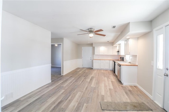 kitchen featuring a wainscoted wall, visible vents, light wood-style flooring, and white cabinets