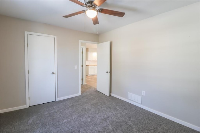 unfurnished bedroom featuring a ceiling fan, carpet, visible vents, and baseboards