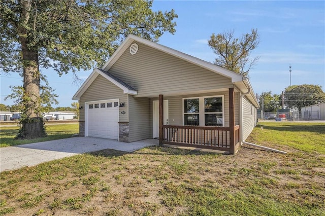 view of front facade with covered porch, concrete driveway, a front lawn, and a garage