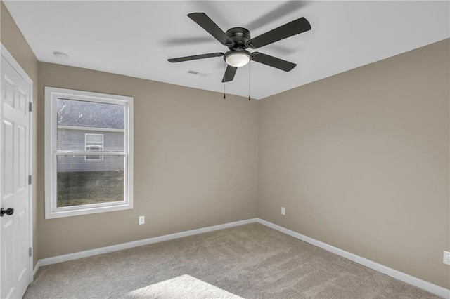 spare room featuring ceiling fan, carpet floors, visible vents, and baseboards