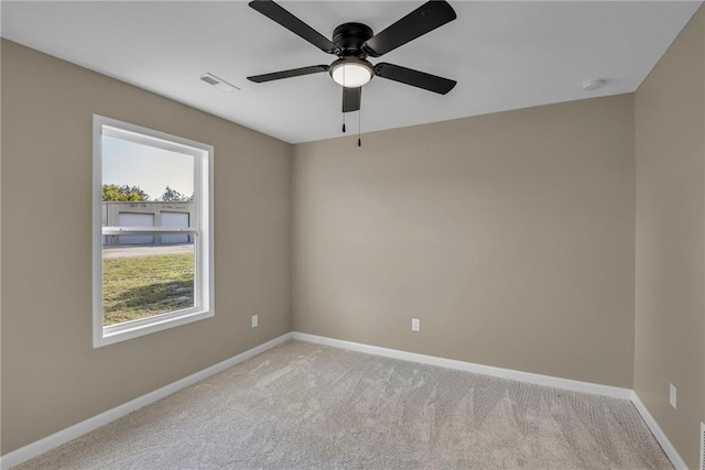 carpeted empty room featuring visible vents, ceiling fan, and baseboards