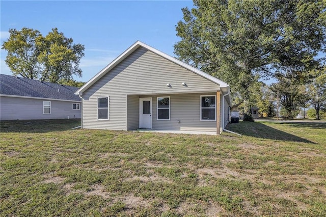 back of property featuring a lawn