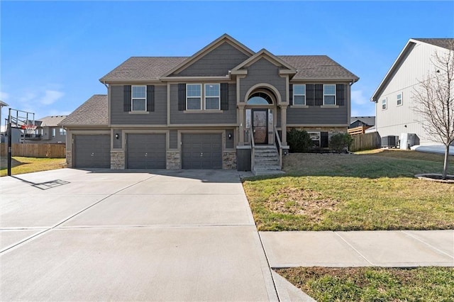 view of front of property with stone siding, driveway, a front lawn, and fence