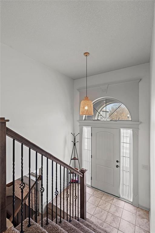 entrance foyer featuring a textured ceiling and tile patterned flooring