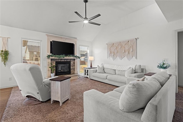 living room with a fireplace, ceiling fan, and vaulted ceiling