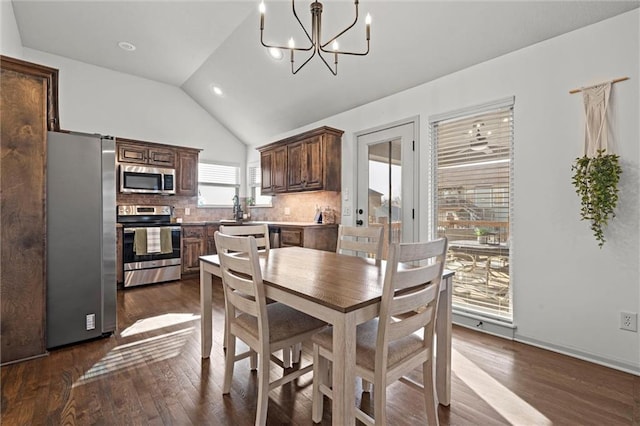 dining area featuring lofted ceiling, an inviting chandelier, and dark wood-style floors