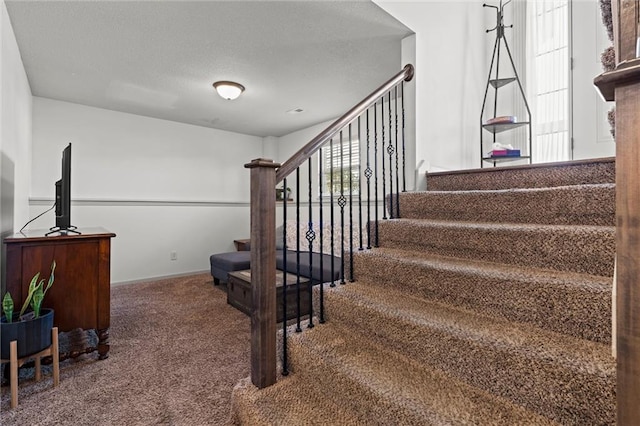 stairs featuring carpet and a textured ceiling