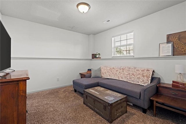 carpeted living area featuring visible vents, baseboards, and a textured ceiling