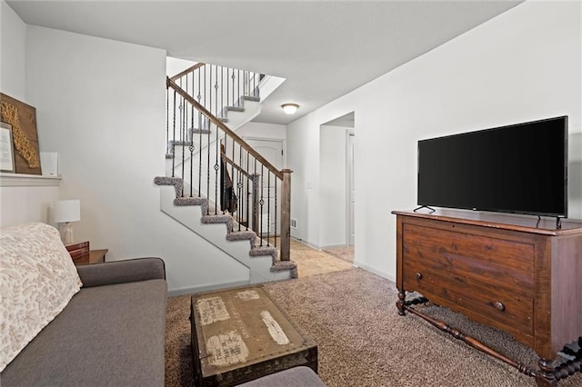 carpeted living room with stairs and baseboards