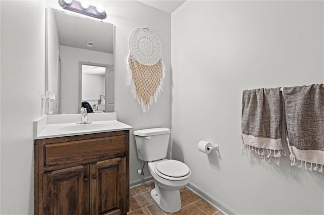 bathroom featuring vanity, visible vents, baseboards, tile patterned flooring, and toilet