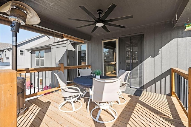 wooden terrace with ceiling fan and outdoor dining space