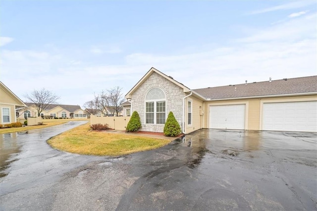 view of front of house featuring stone siding and aphalt driveway