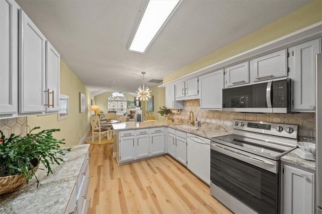 kitchen with a peninsula, open floor plan, stainless steel electric range, backsplash, and dishwasher