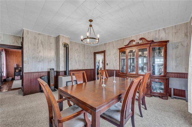 dining space featuring a wainscoted wall, carpet, and a notable chandelier