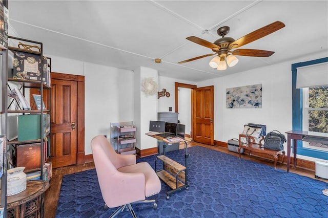 living area featuring baseboards, ceiling fan, and wood finished floors