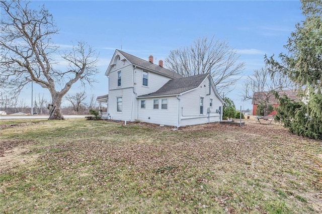 view of side of property with a lawn and a chimney