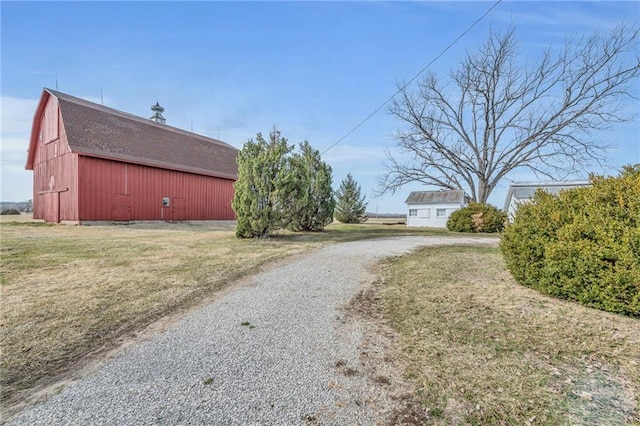 view of road with a barn and gravel driveway