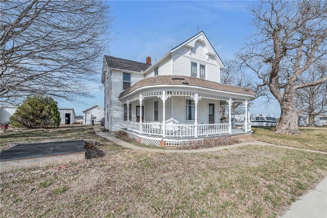 victorian home featuring a chimney, a porch, and a front lawn