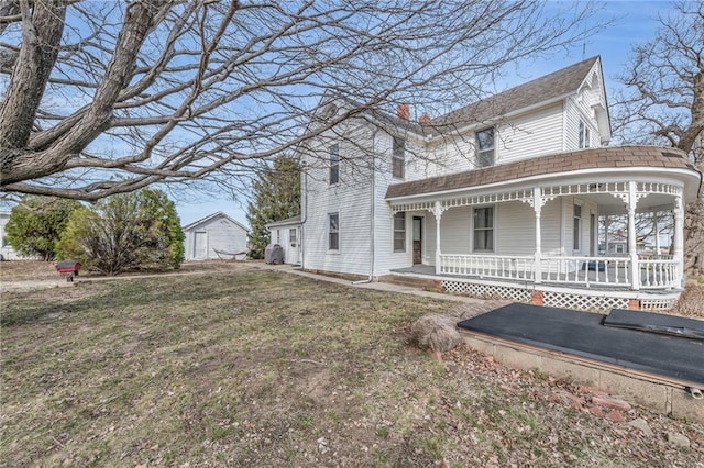 view of front of property with a porch, a chimney, a front lawn, and roof with shingles