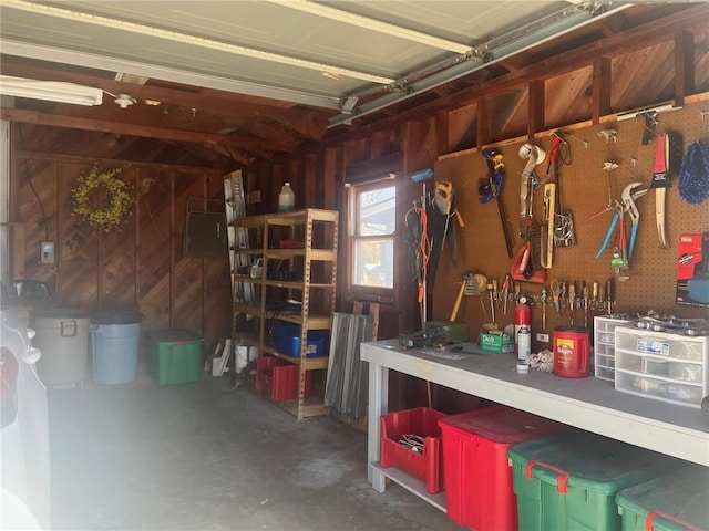 garage with a workshop area and wooden walls