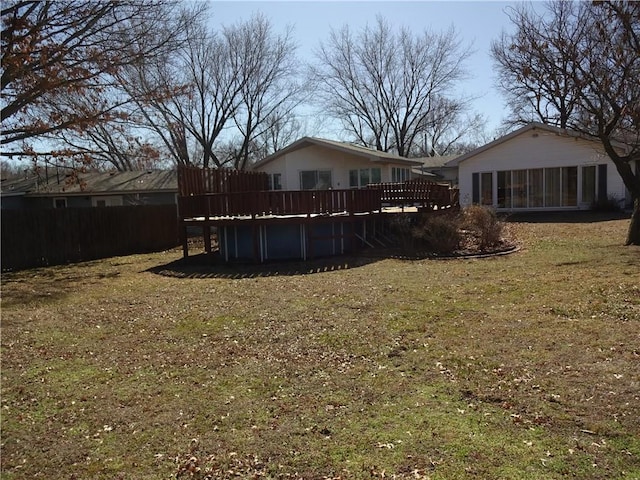 view of yard featuring a sunroom, fence, and a wooden deck