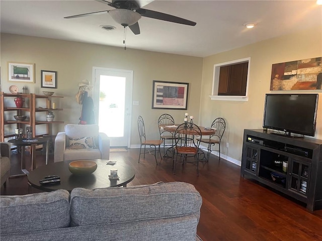 living room with visible vents, ceiling fan, baseboards, and wood finished floors