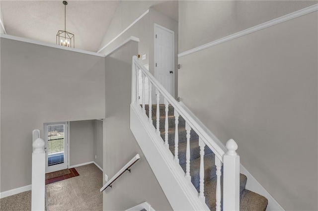 stairway with baseboards, carpet, an inviting chandelier, and high vaulted ceiling