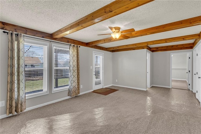 unfurnished room with beam ceiling, plenty of natural light, baseboards, and a textured ceiling