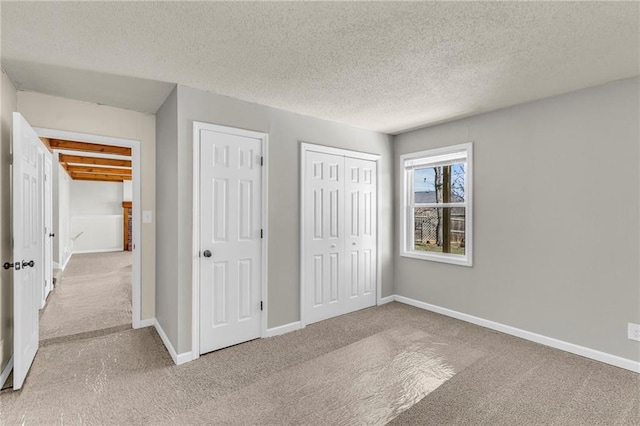 unfurnished bedroom featuring baseboards, carpet floors, and a textured ceiling