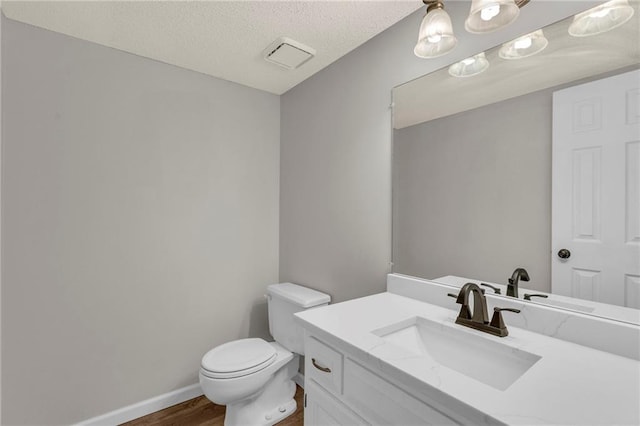 bathroom with visible vents, toilet, wood finished floors, baseboards, and vanity